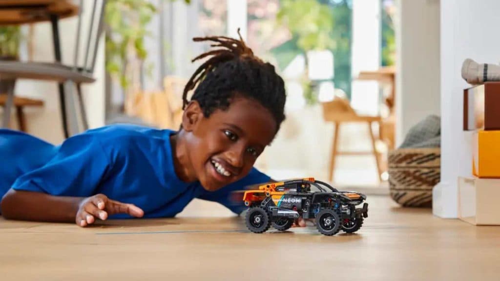 A child playing with the LEGO Technic NEOM McLaren Extreme E Race Car