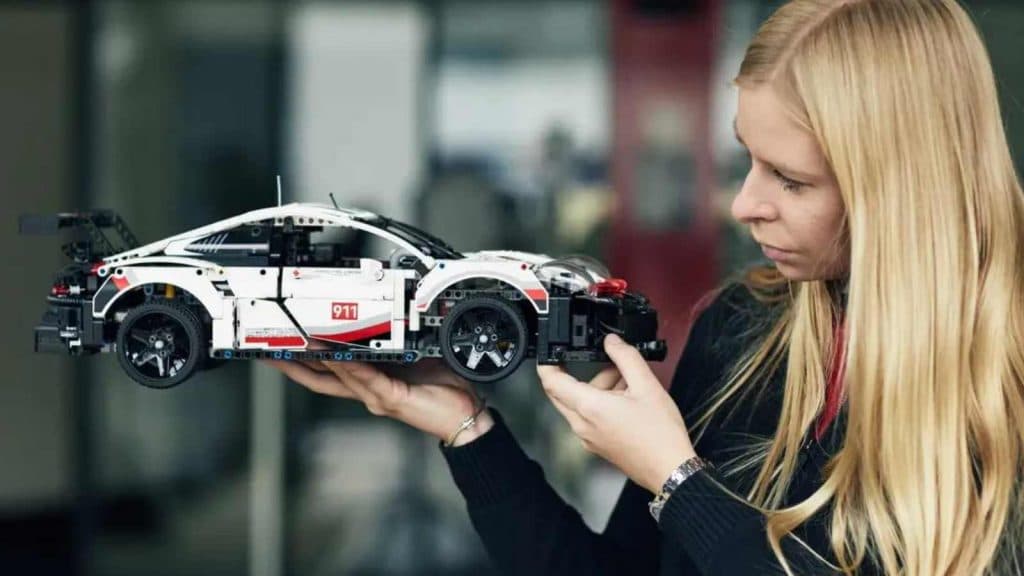 An adult admiring the LEGO Technic Porsche 911 RSR