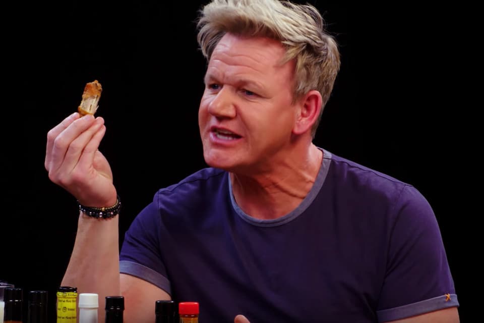 Gordon Ramsey eating a chicken wing on Hot Ones.