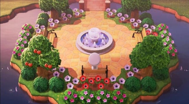 An image of a park island layout in Animal Crossing new horizons featuring fruit trees, flowers, a lake and a fountain
