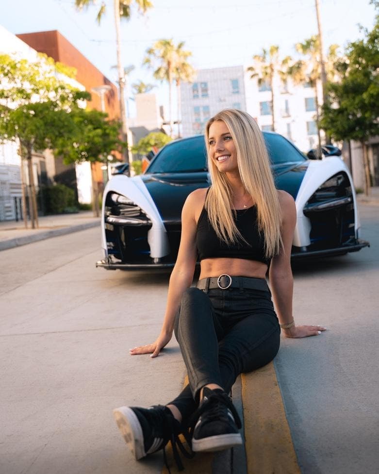 Lindsay Brewer poses on the street with her car.