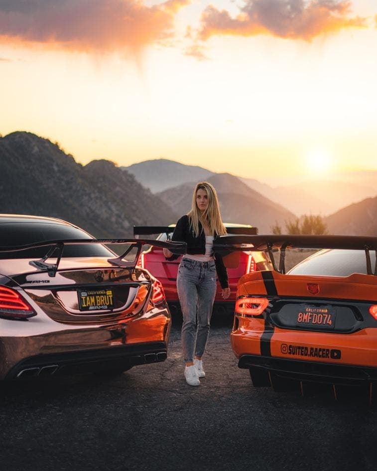 Lindsay Brewer poses with her cars as the sunsets