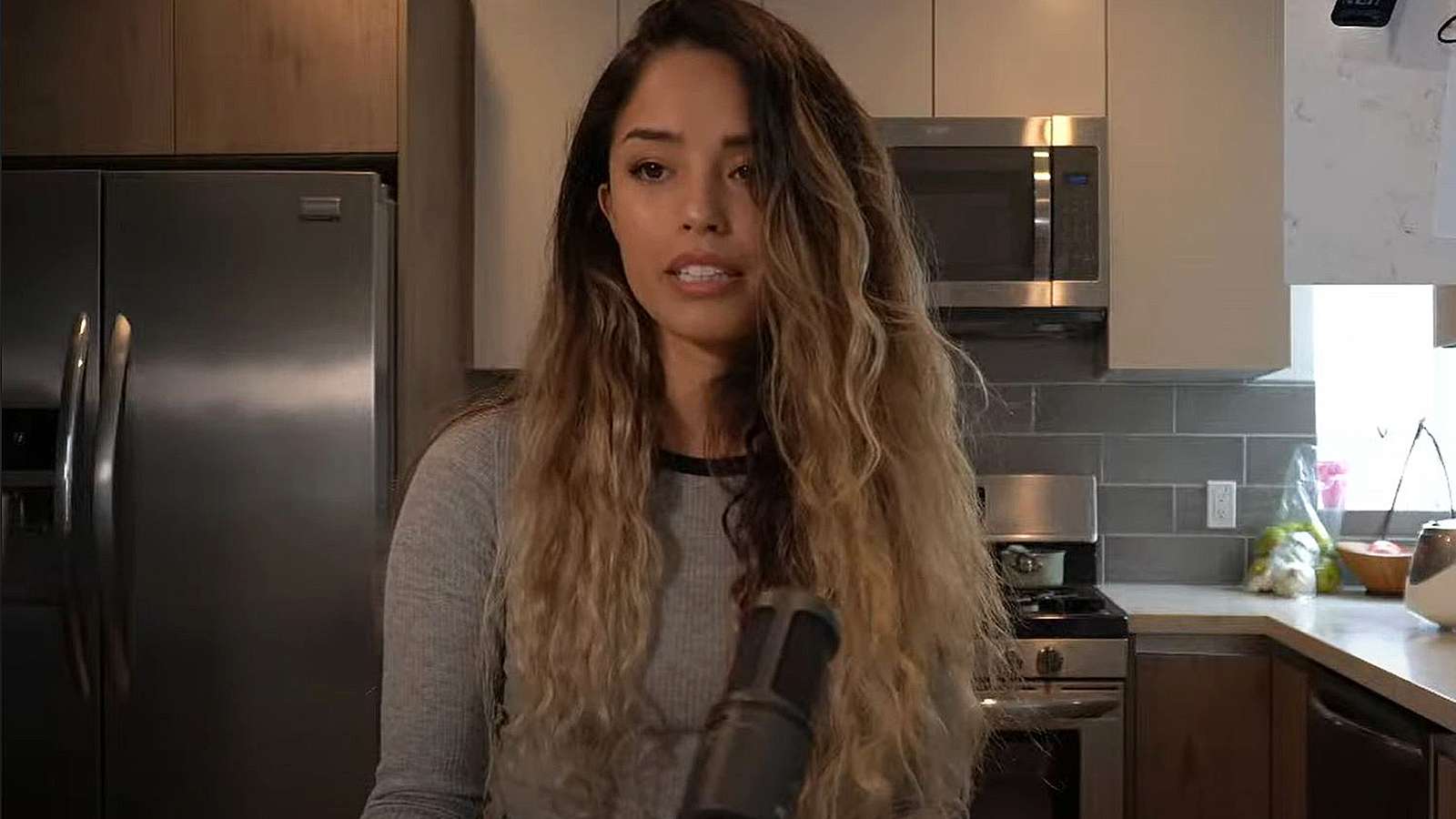 Valkyrae speaks to the camera from her kitchen.