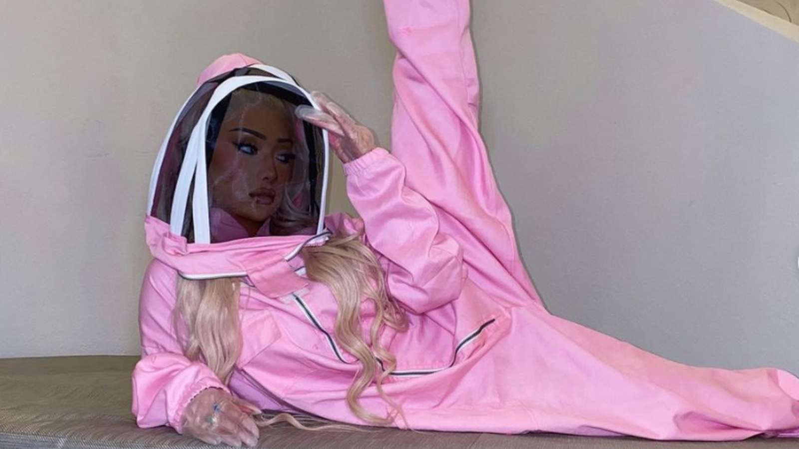Nikita Dragun posing in a pink hazmat suit