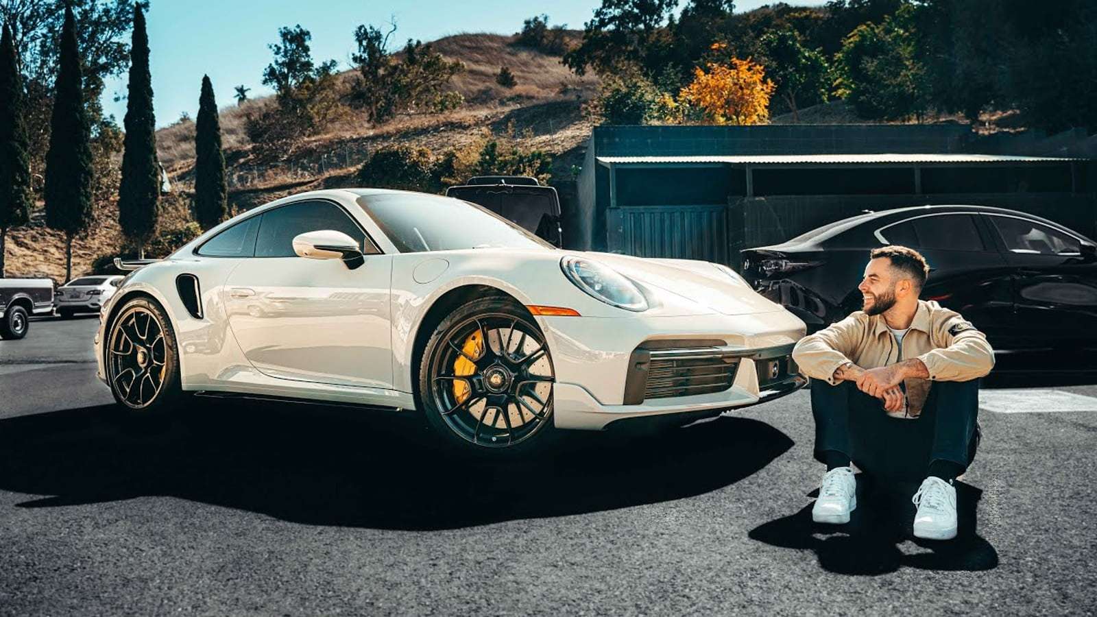 Nadeshot sitting in front of his new Porsche