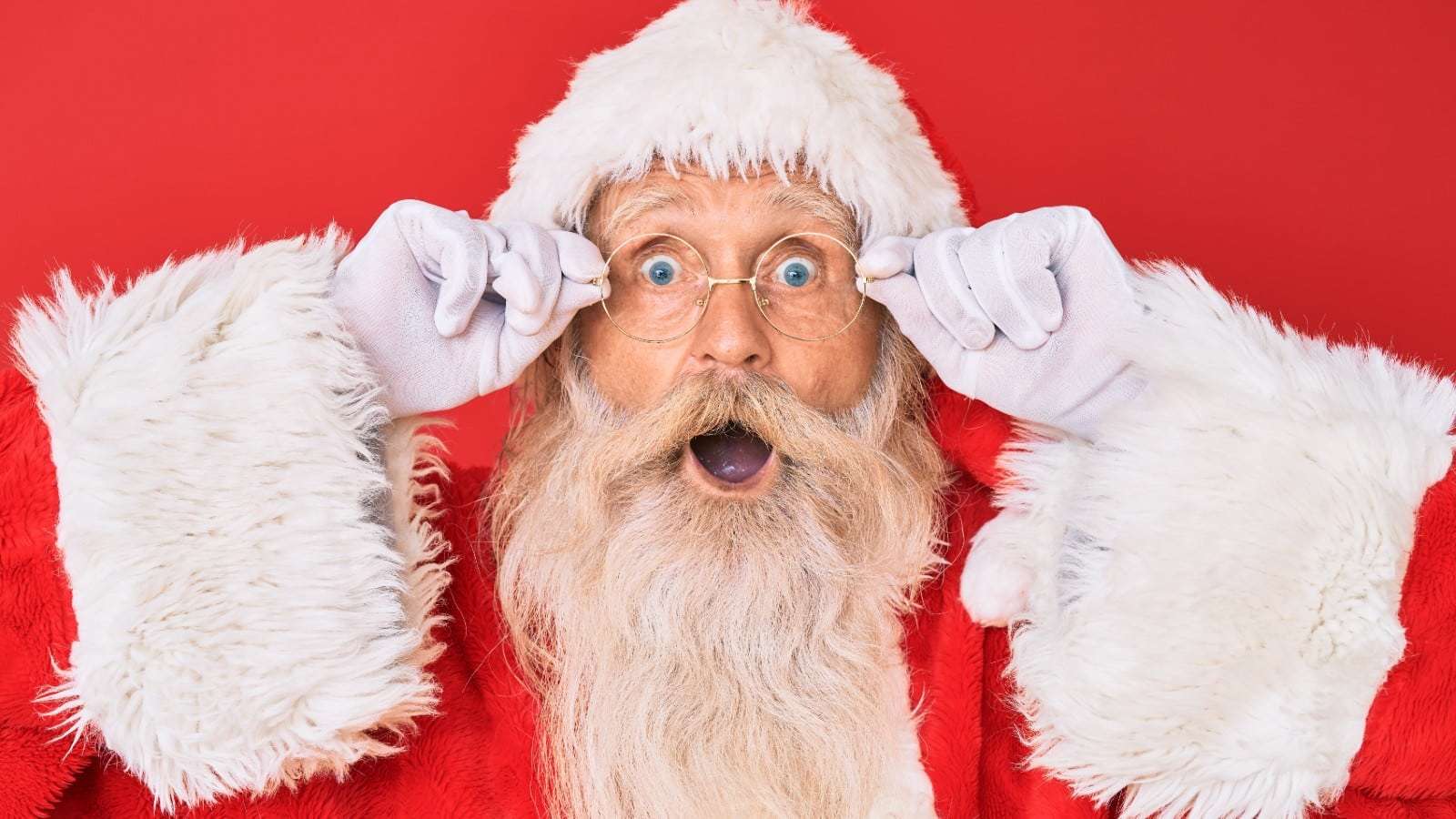 Santa holding his glasses with an excited face