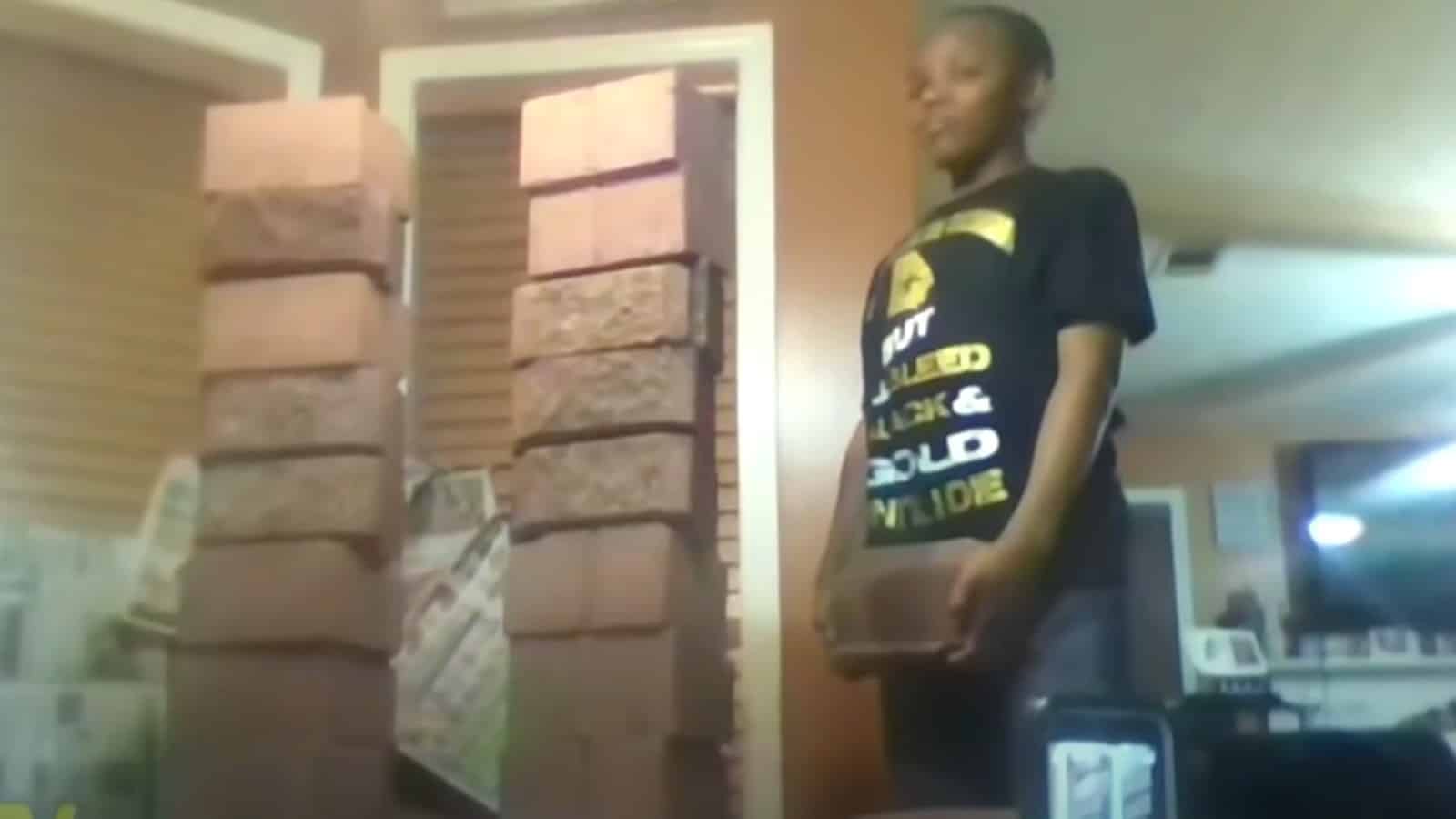 Boy stands next to stacks of bricks
