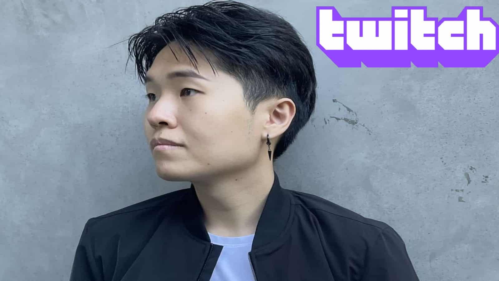 Streamer DisguisedToast standing in front of abrick wall with Twitch logo superimposed next to him.