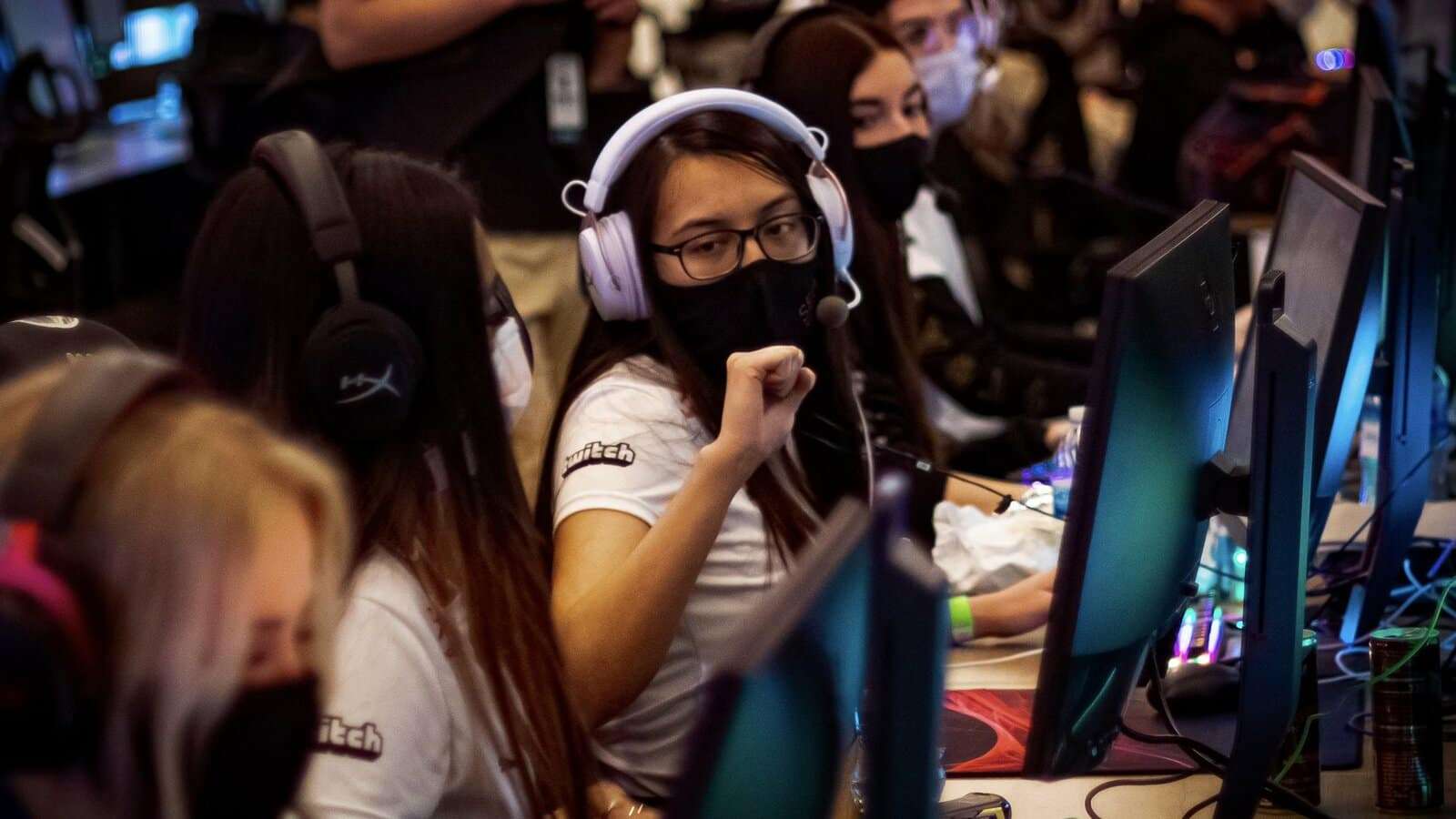 MeL fist bumps her teammates at a LAN tournament wearing a C9 jersey and black mask