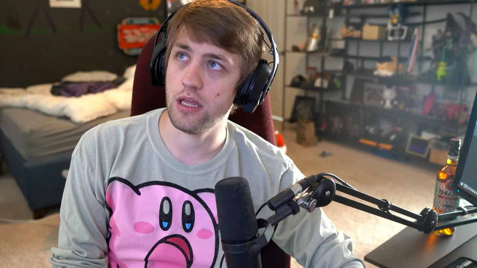 Sodapoppin sitting in a gaming chair with a grey kirby jumper on
