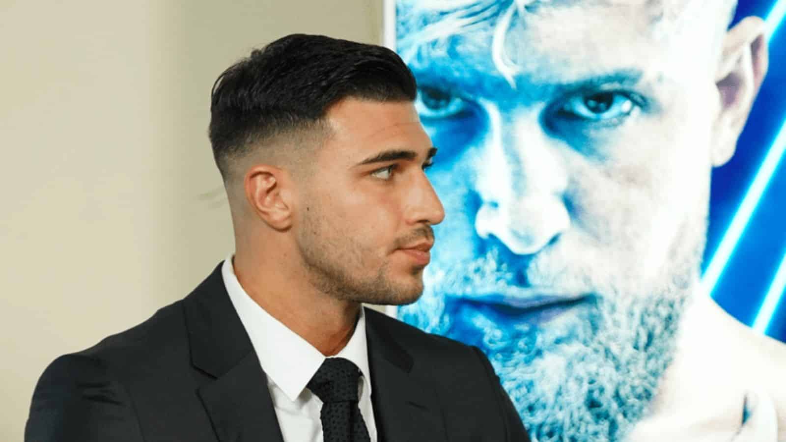 Tommy Fury in front of monitor with Jake Paul's face glaring out
