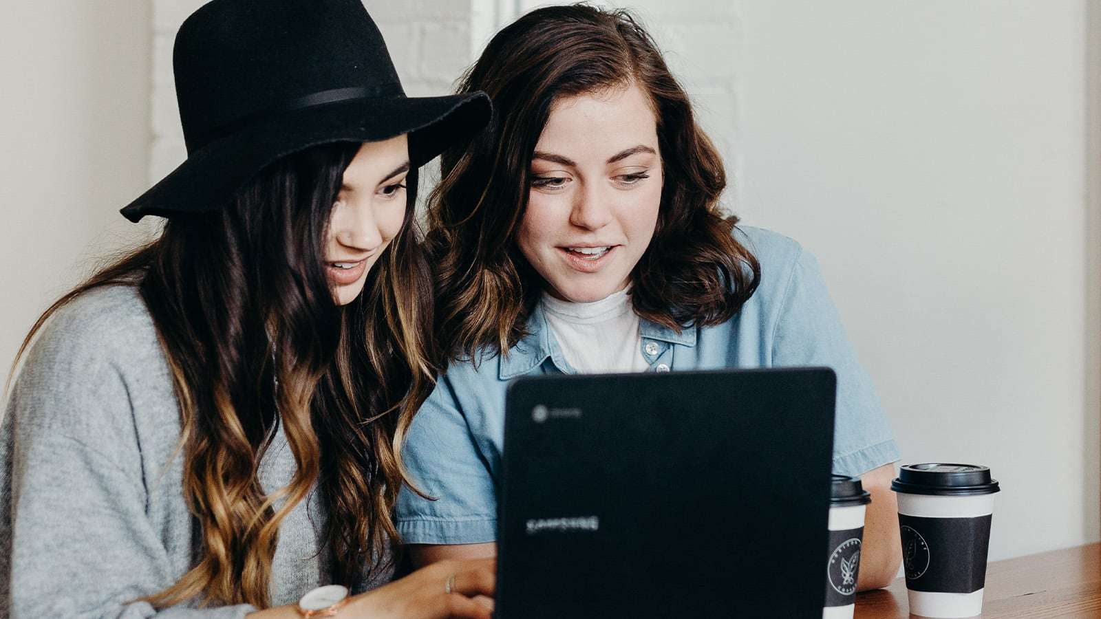 two girls sitting in front of a computer