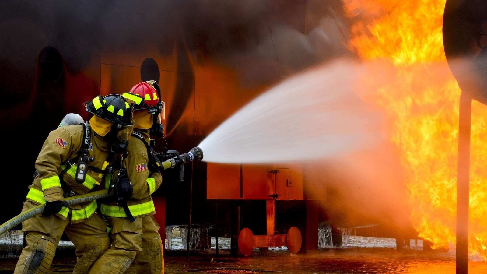Image of firefighters taking on a house fire.