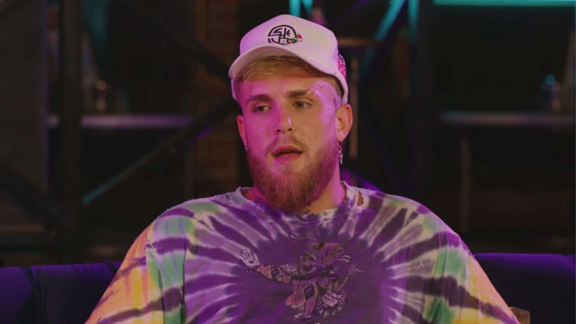 Jake Paul talking to camera in tie dye shirt and hat