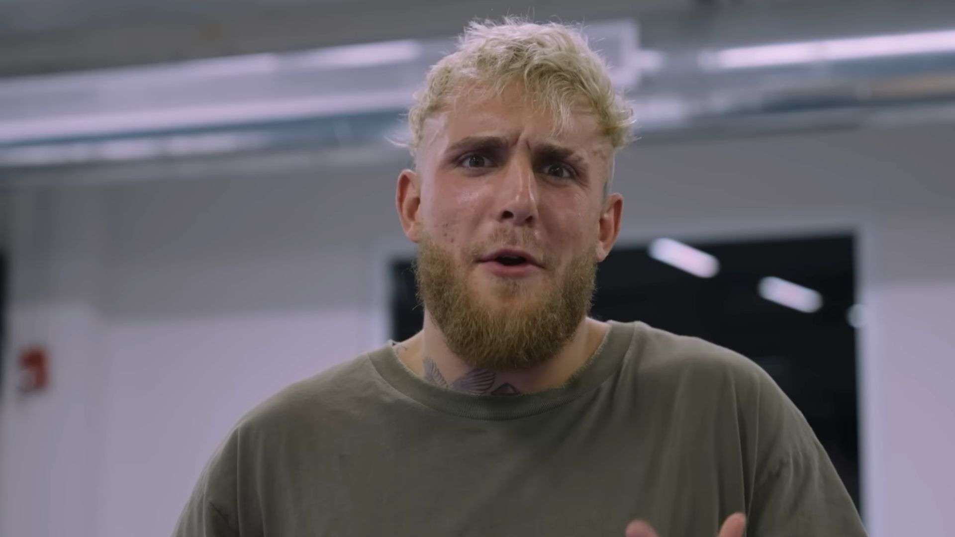Jake Paul talking to camera in boxing gym with green t shirt