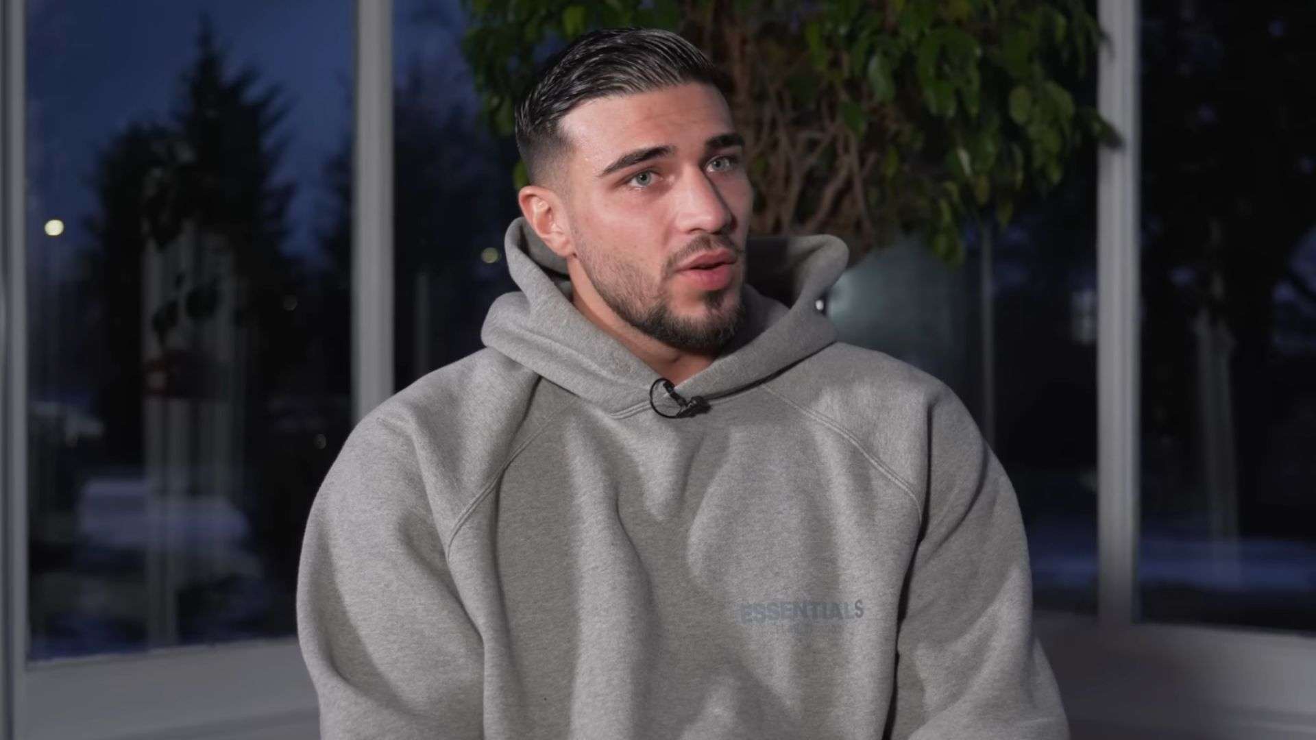 Tommy Fury in a grey jumper talking to camera