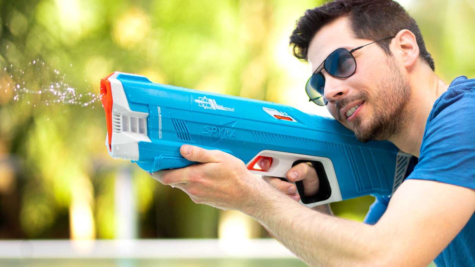 Man holding a SpyraThree Gun, with it shooting water