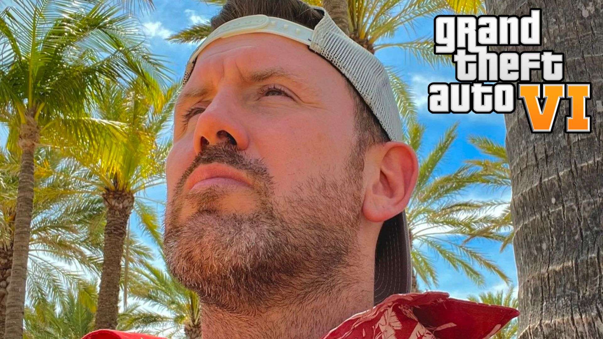 Actor Bryan Zampella sat on beach in red shirt next to GTA 6 logo