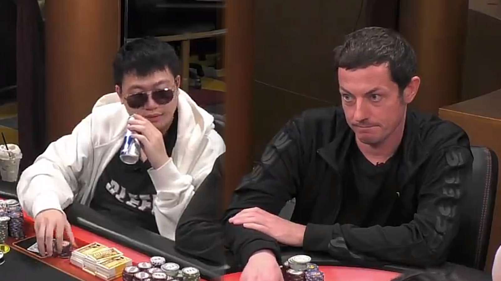 Wesley Fei and Tom Dwan looking at each other during pre-flop phase of a poker game.