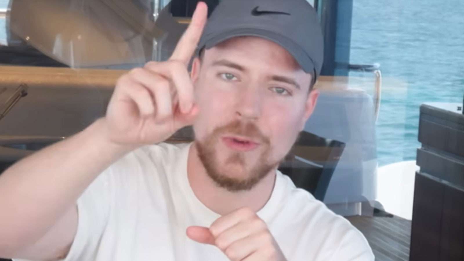 MrBeast holding up his finger while sat at a table on a Yacht