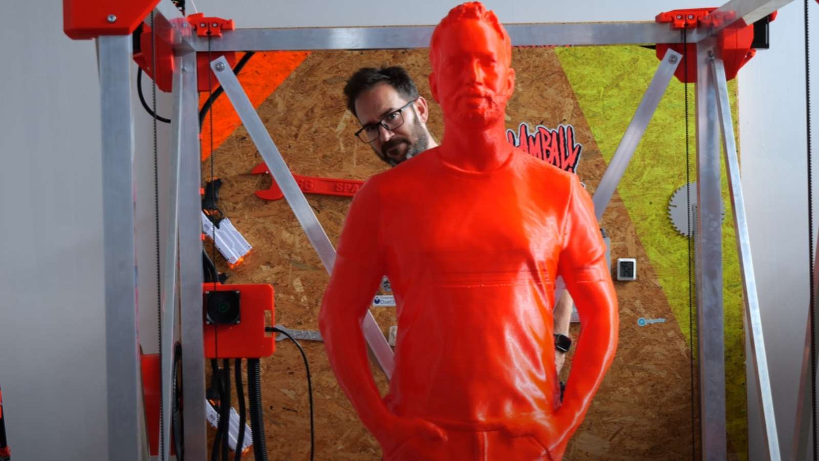 Youtuber stood behind red 3D printed clone of himself
