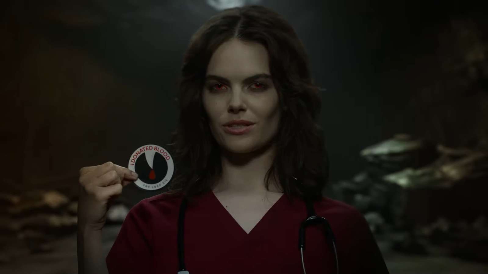 A nurse holding a sticker reading "I donated blood for Lord Zir."