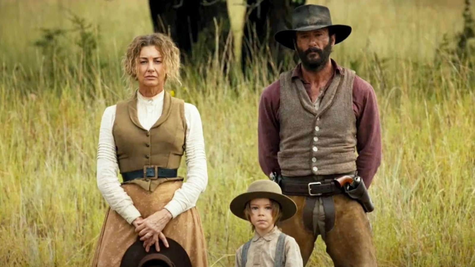 Yellowstone 1883: The Dutton family stand together in tall grass, looking at the camera