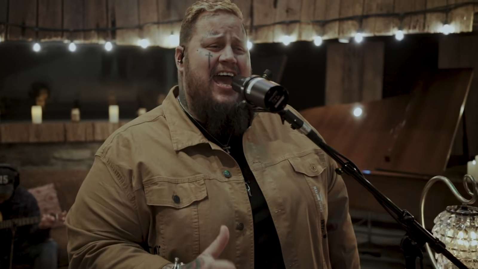 Jelly Roll singing with a microphone in an acoustic video