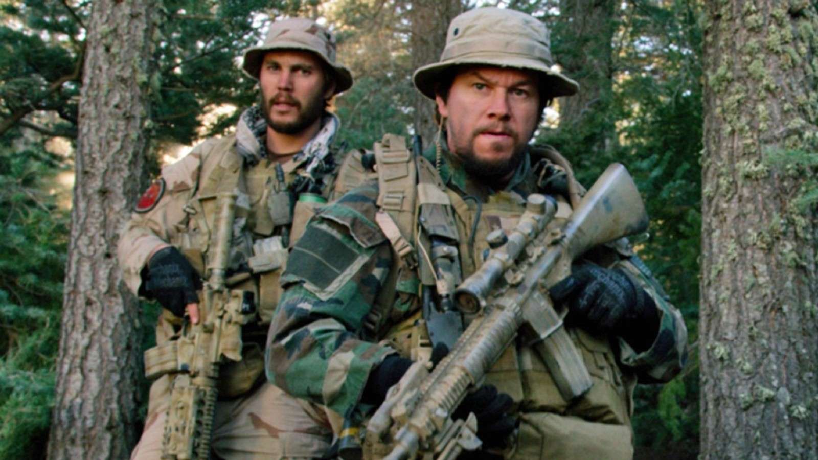 Taylor Kitsch and Mark Wahlberg carrying guns into war during Lone Survivor.