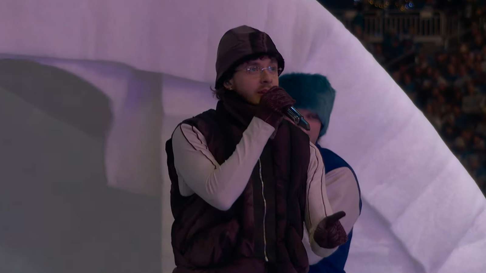 Jack Harlow performing onstage on an igloo on a football field