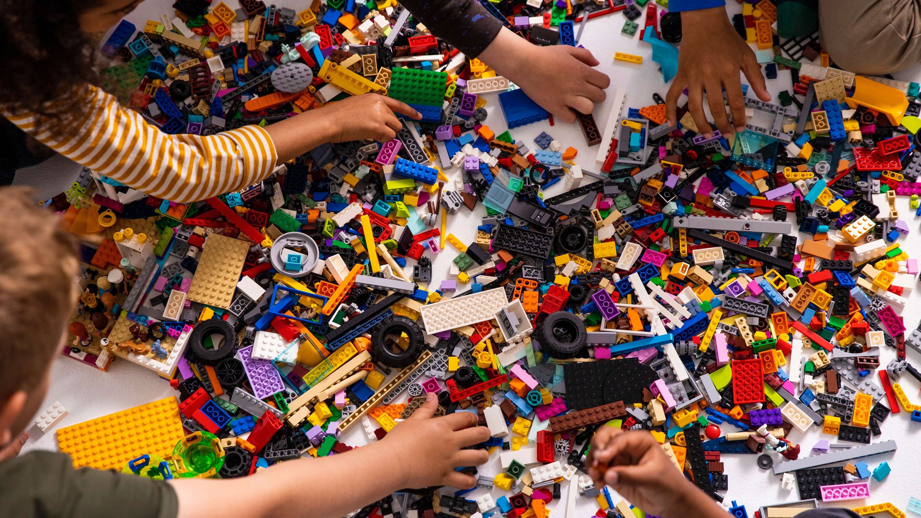 Five children pick bricks to create their own LEGO creations.