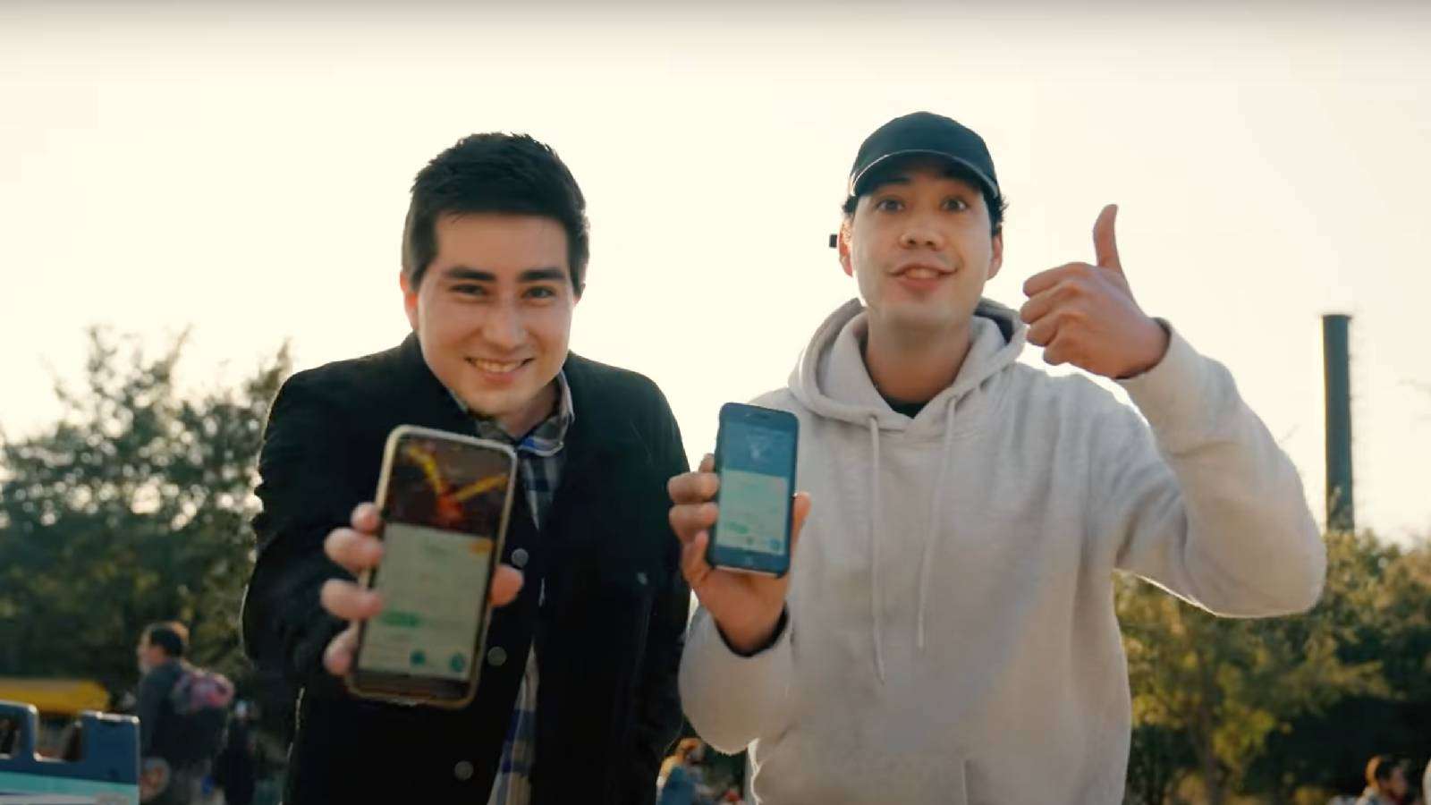 Two Pokemon Go fans hold up their phones with rare Pokemon shown on the screens