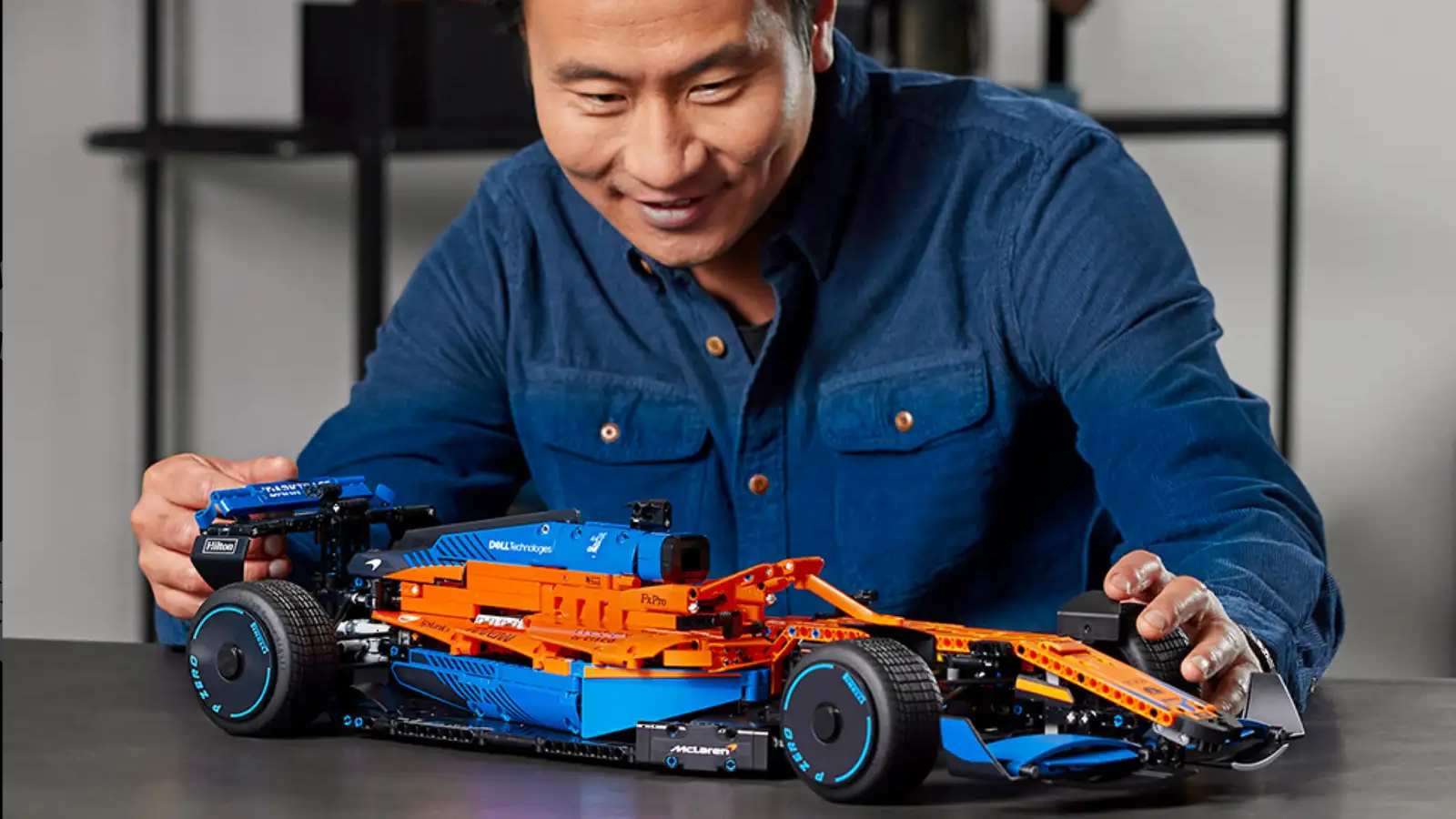 An adult admiring their LEGO Technic McLaren F1 race car.