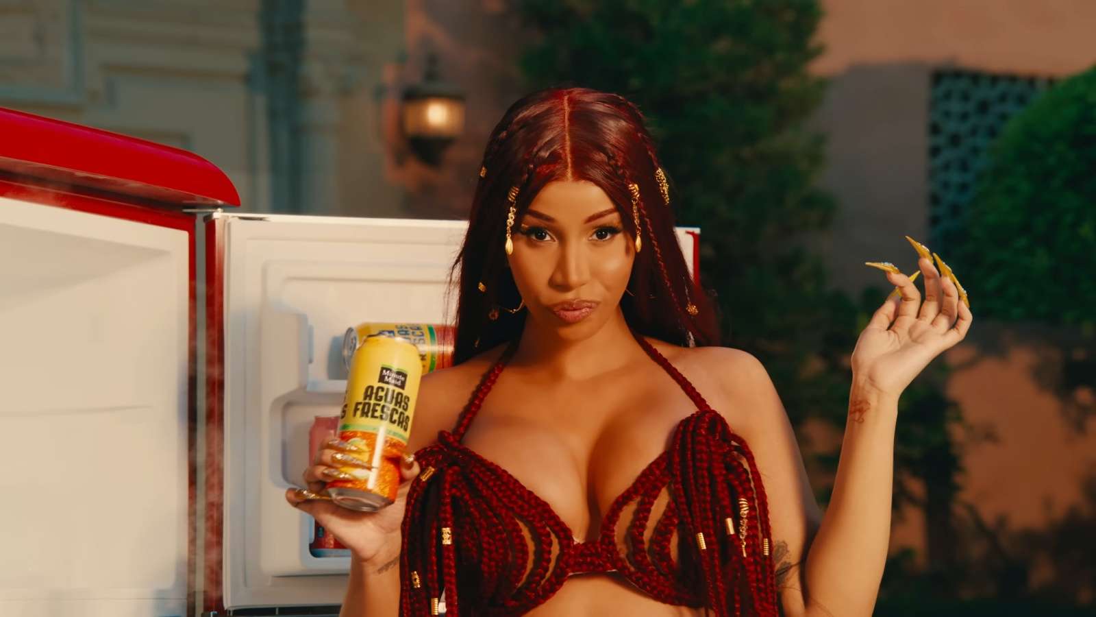 Cardi B holding a drink by the pool