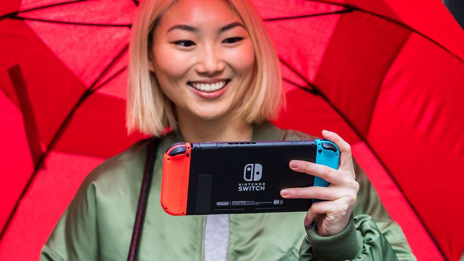 Woman holding a red & blue Nintendo Switch