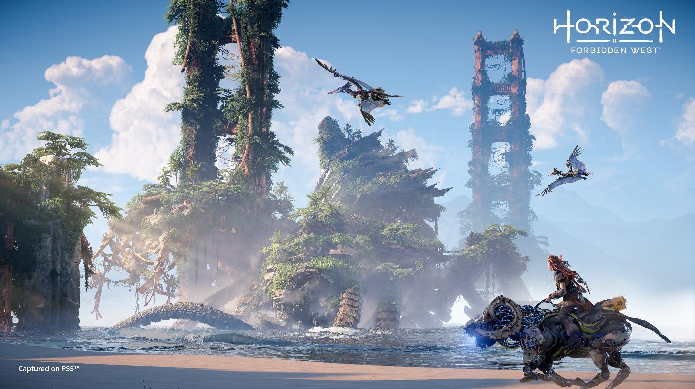 Aloy riding on a mechanical creature along a beach with the Golden Gate Bridge