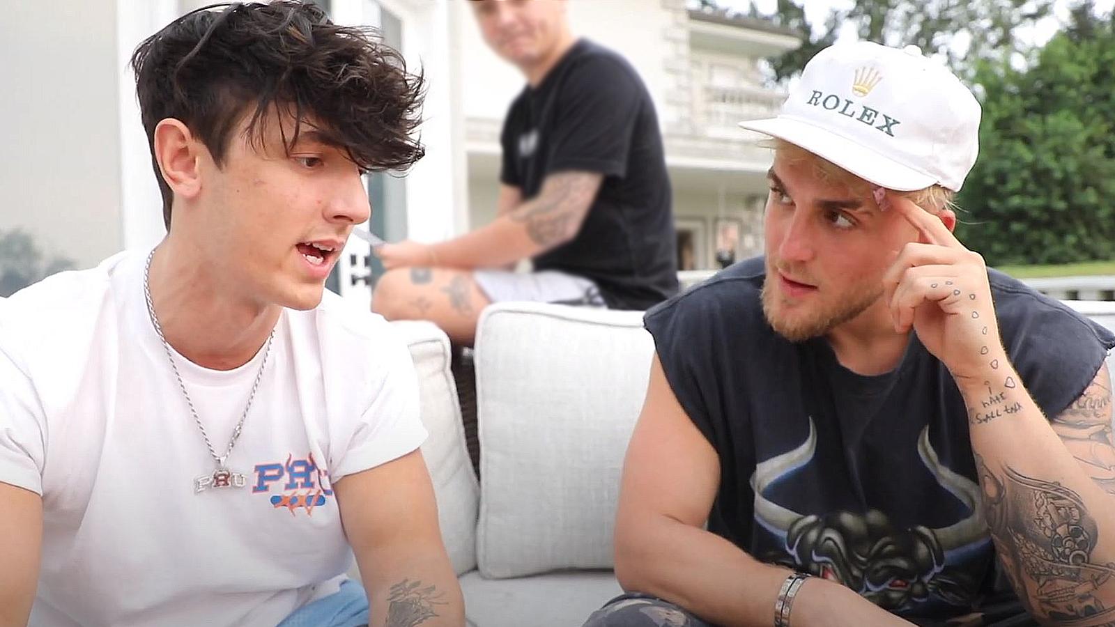 Bryce Hall and Jake Paul speak while sitting on a couch outside.