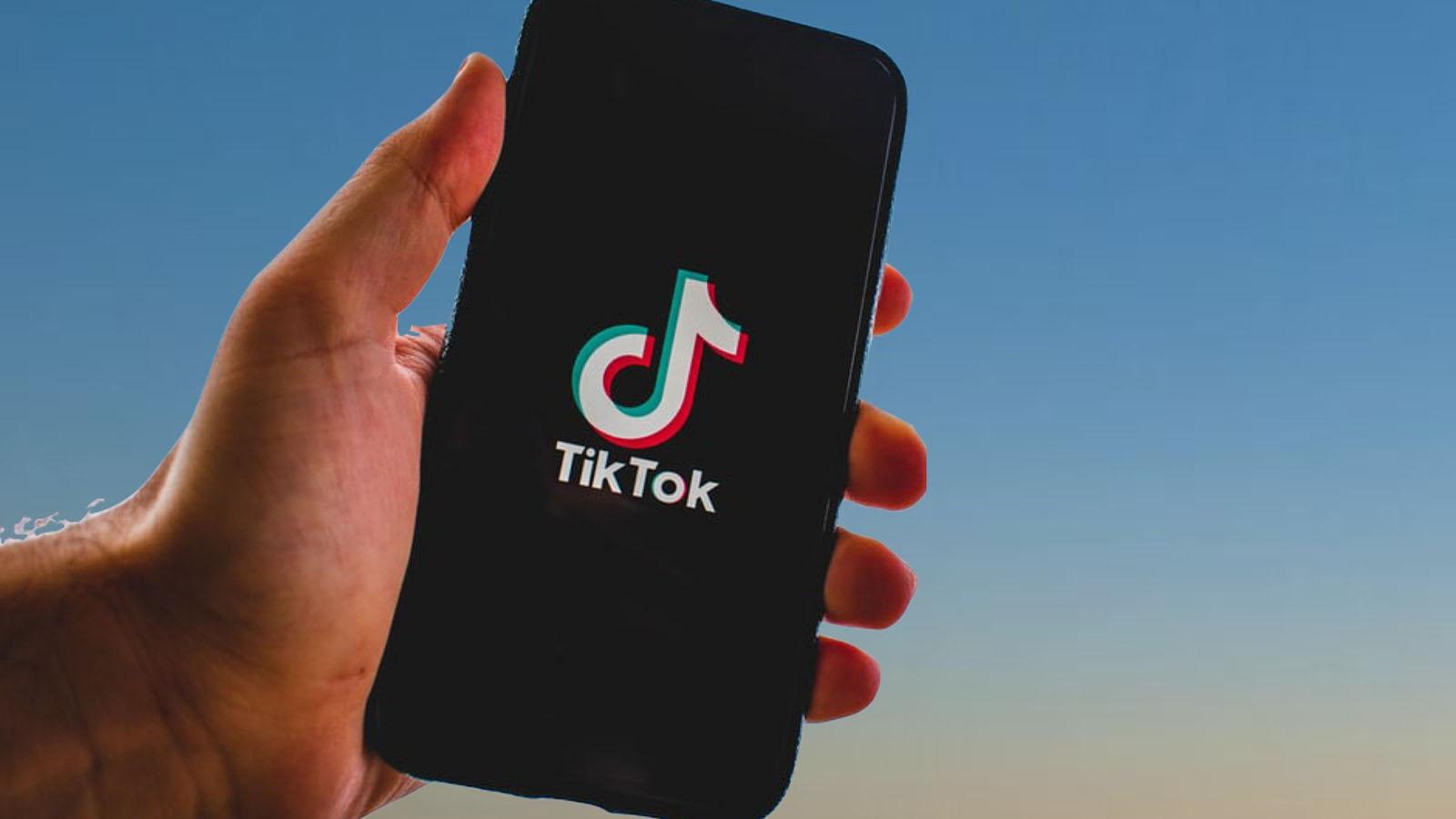 TikTok launch screen on phone in front of sky