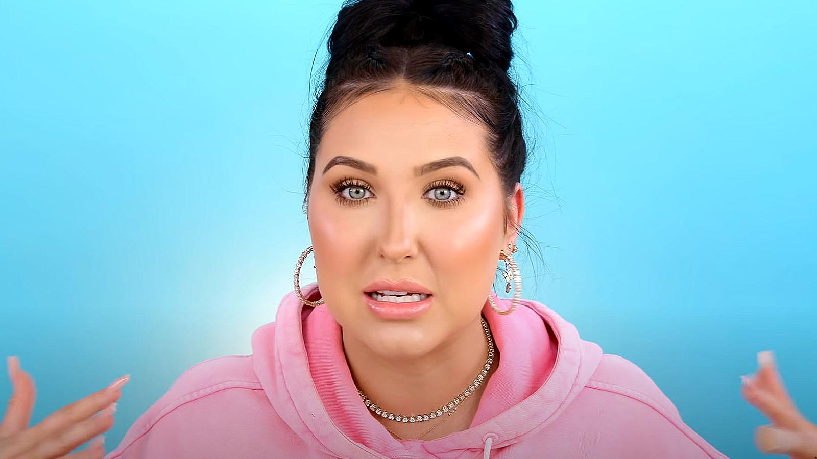 Jaclyn Hill speaks to her fans against a blue background.