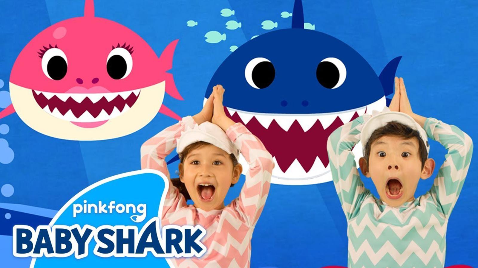 Two children dance to the Baby Shark song against an ocean background.