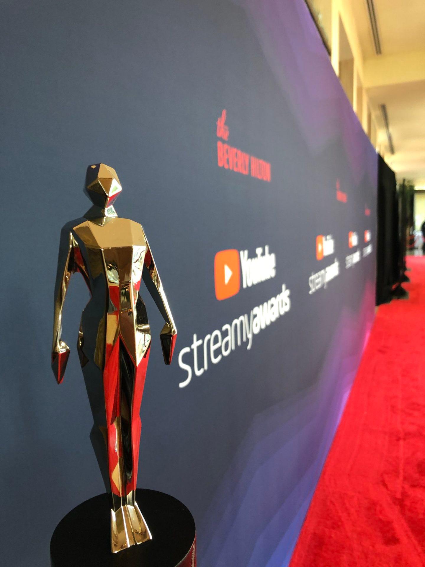 A photo of a Streamy Award trophy on the red carpet.