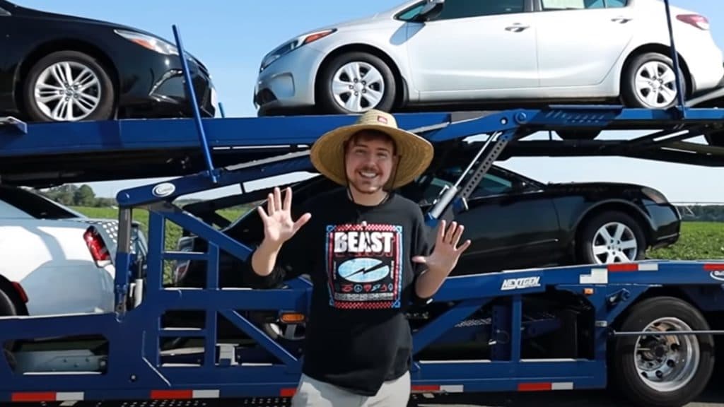 mr beast standing in front of cars