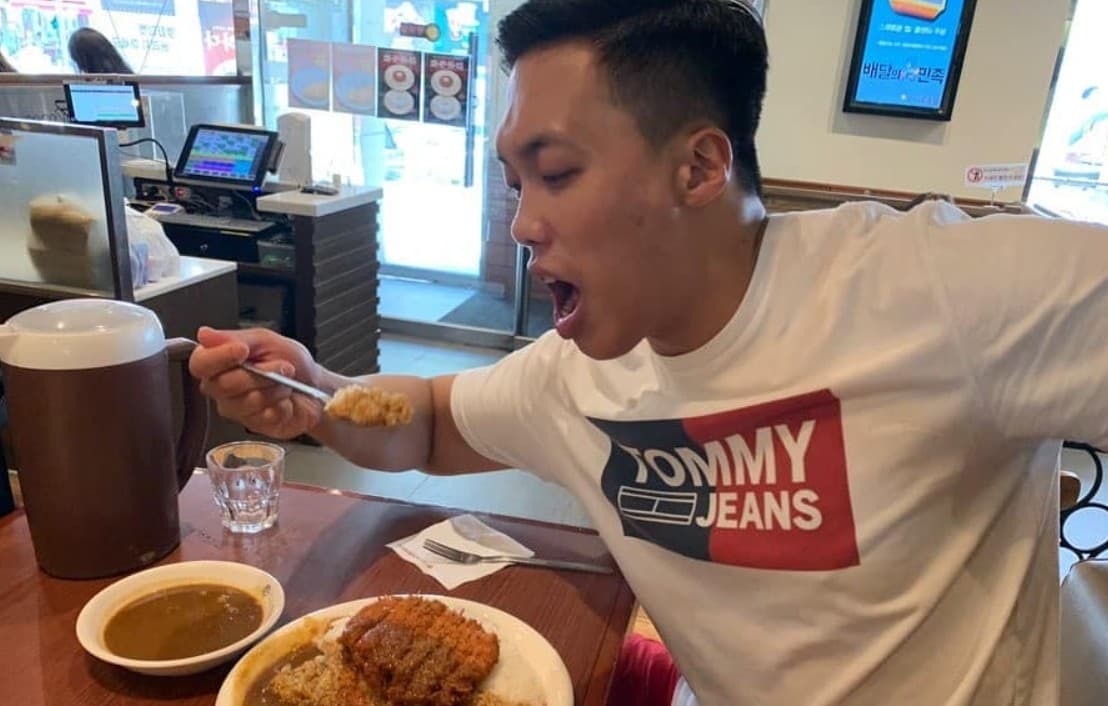 Streamer Lee Sang Deuk poses in front of a table full of food