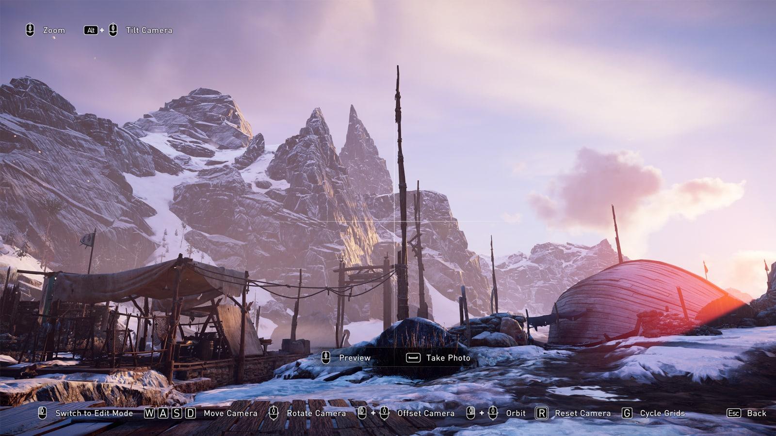 Screenshot of Valhalla's photo mode option showing the UI and a beautiful snowy mountain alongside a settlement.