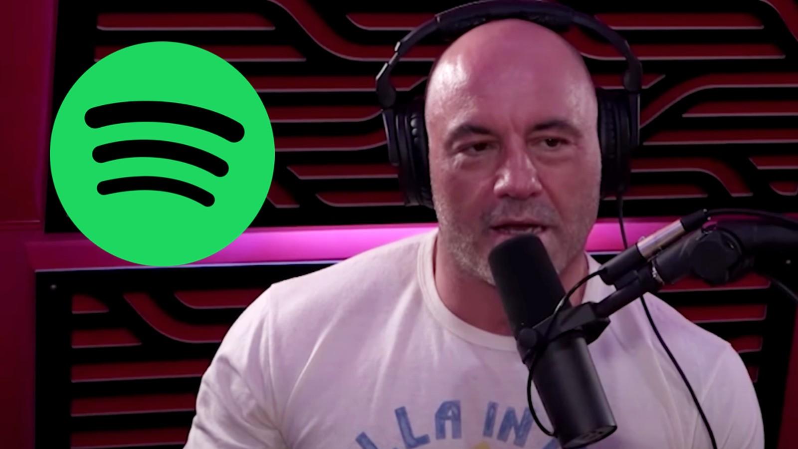Joe Rogan in his podcast studio next to the Spotify logo