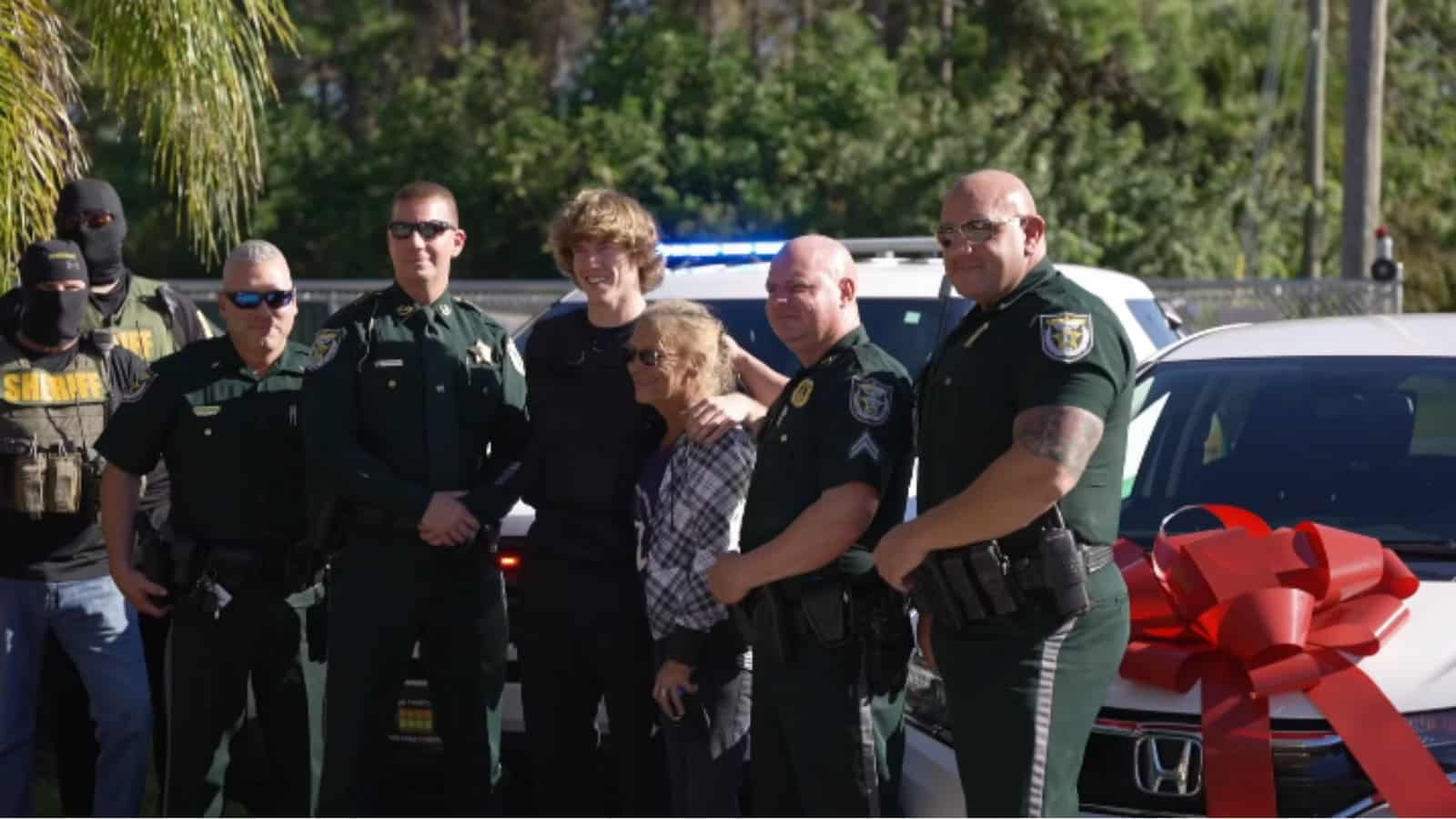 Danny Duncan poses with police and a woman with a new car