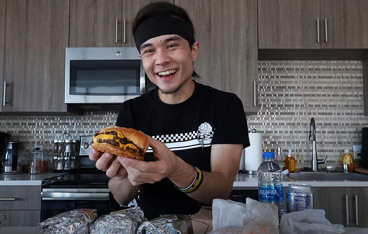 Matt Stonie smiles with a burger