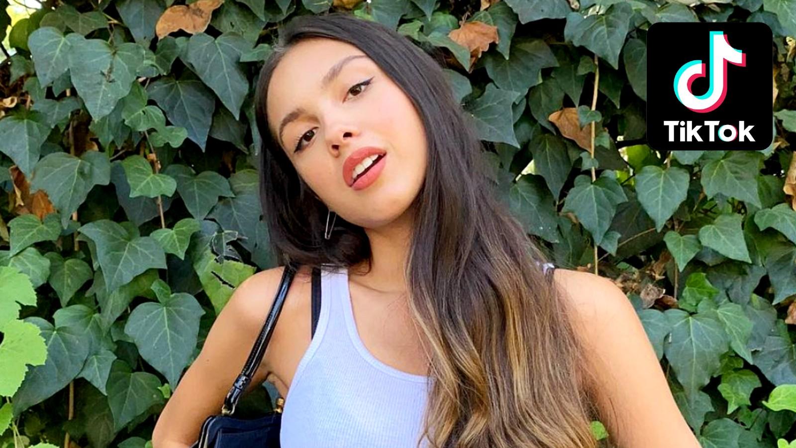 Olivia Rodrigo poses in front of some leaves