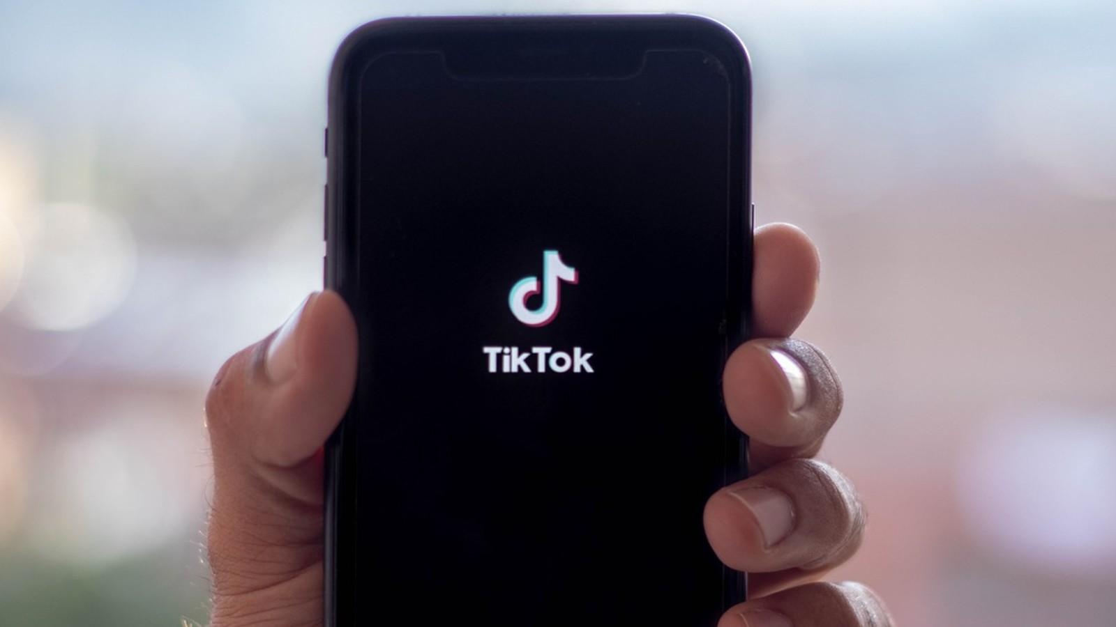 The TikTok launch screen phone held by a hand