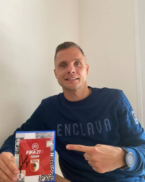 rafal gikiewicz with a copy of FIFA 21